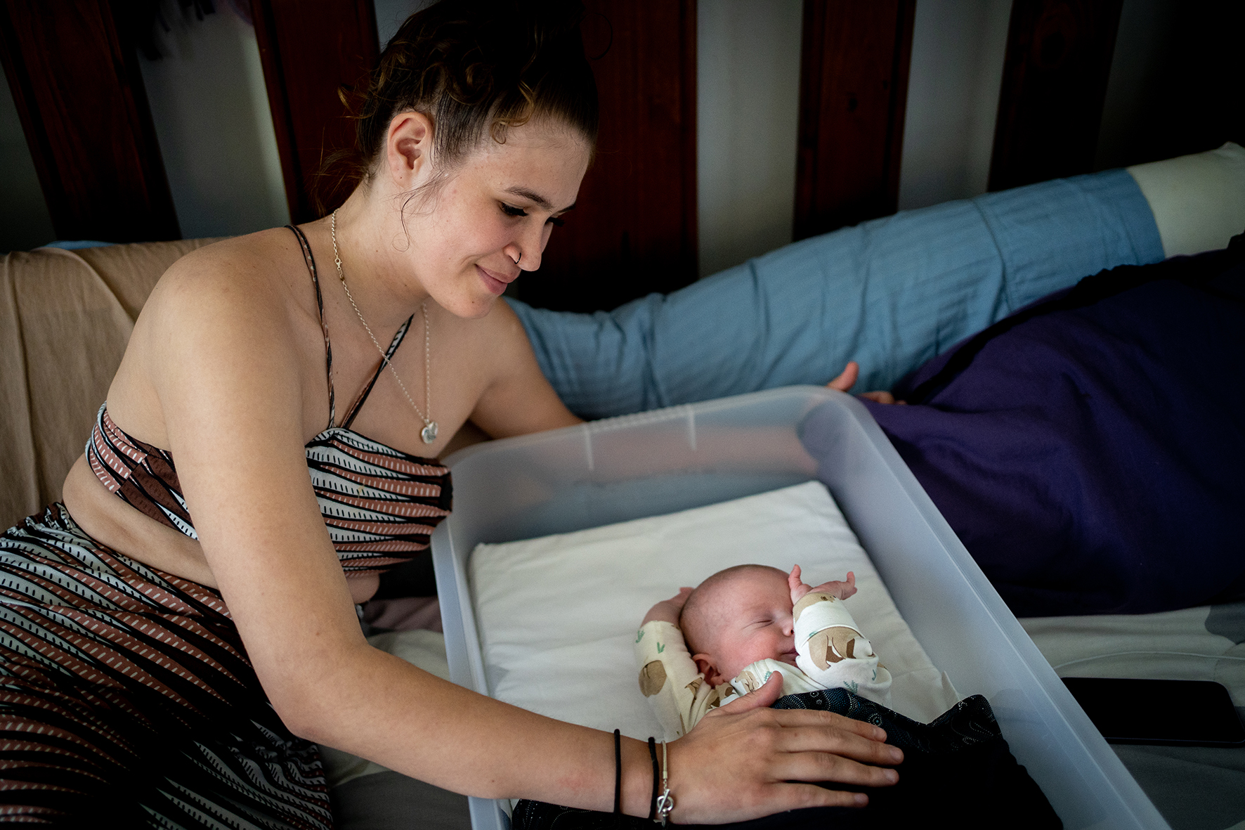 Lekira Wilkinson at home with her baby Leo in a Pēpi-Pod portable infant bed-edit