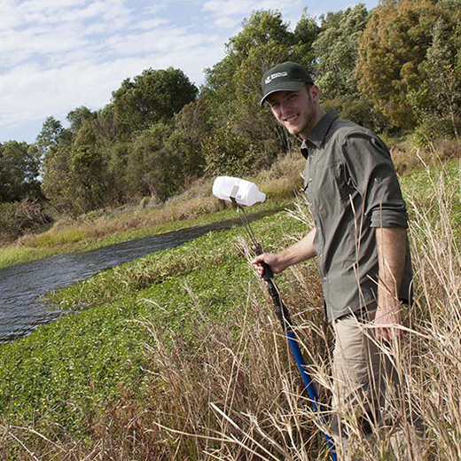 A USC student conducting water testing at a lake on the Sippy Downs campus.