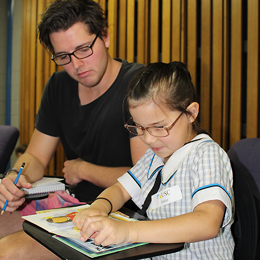 A USC Education student completes a Ready Reading exercise with a primary school student  