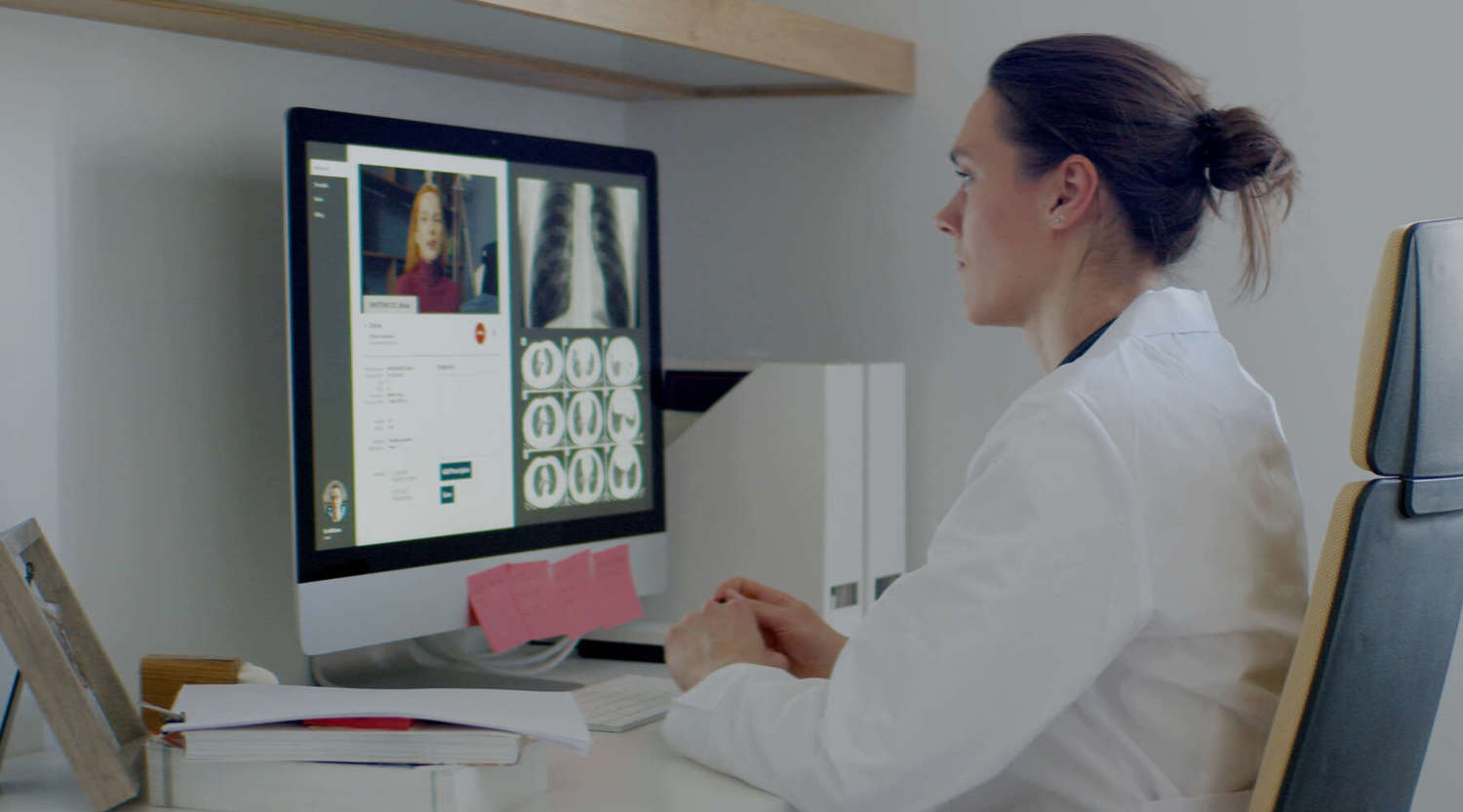 Caucasian female doctor delivering telemedicine consultation to a patient via computer