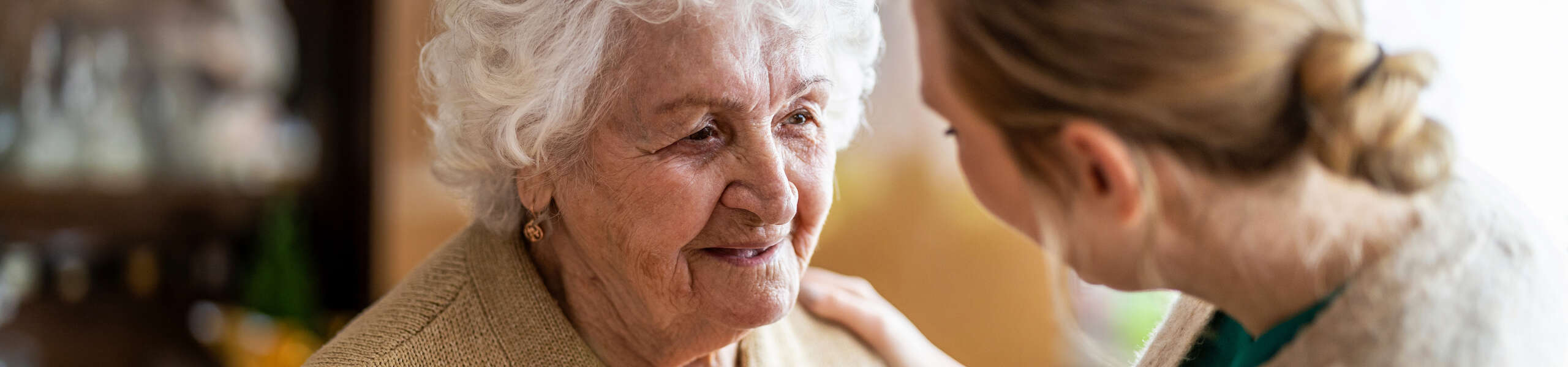 lady with hand on shoulder of elderly person